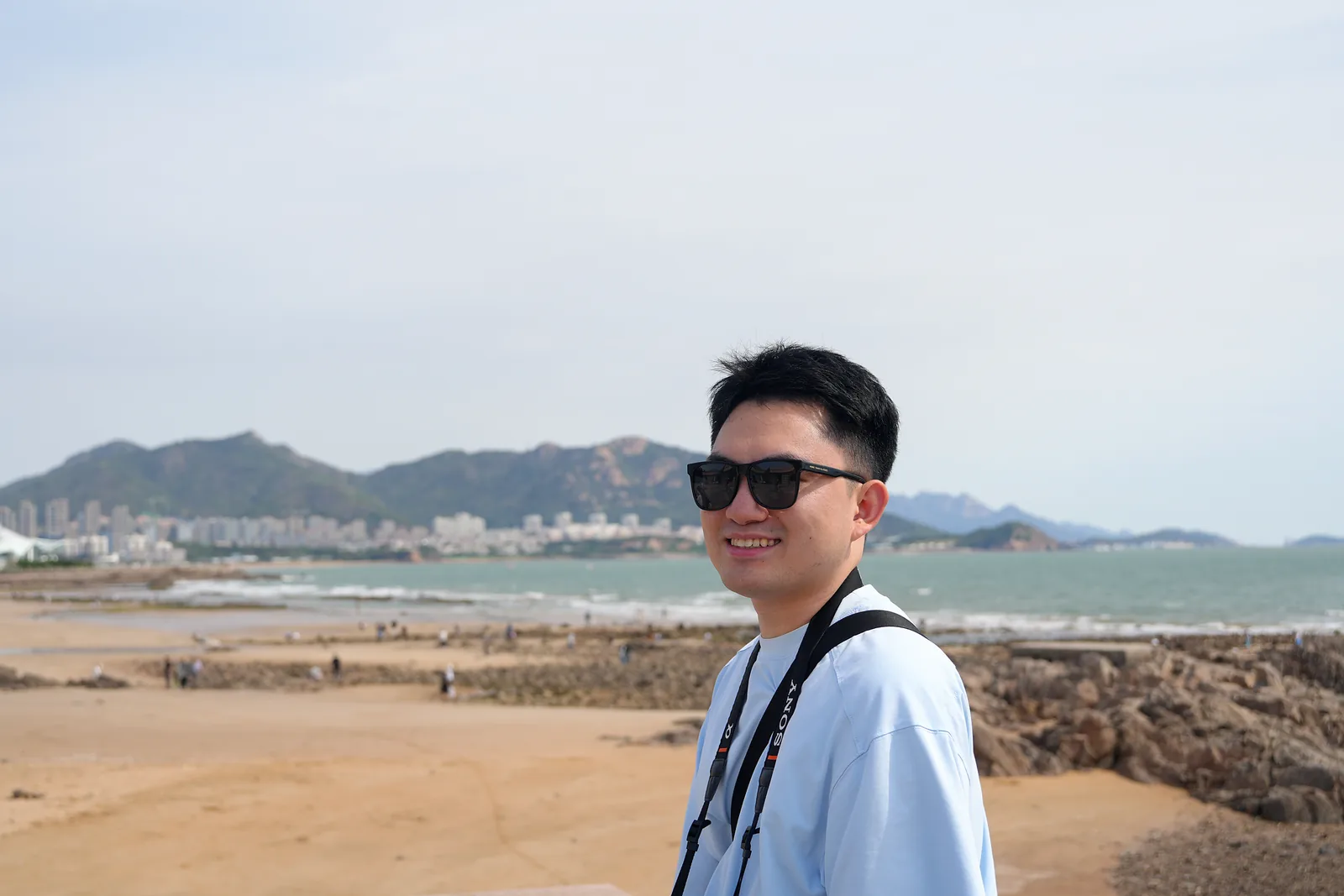 Yipeng Liu smiling by the coast